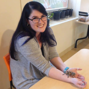 Photo of Marketing & Events Coordinator, Morgan McNeill, holding Rosie the tarantula.