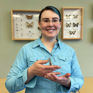 Photo of staff member, Miriam Bayer, holding a praying mantis.